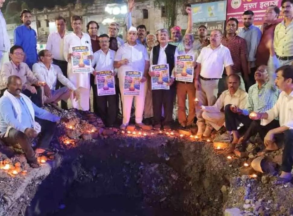 गड्ढे में बैठकर कांग्रेस ने जलाया दीया, शहर की बदहाल सड़कों पर जताया विरोध